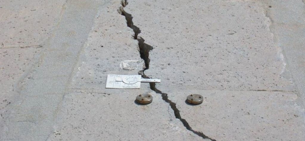G6 gauge fixed with self-adhesive tabs on a crack with uneven width
