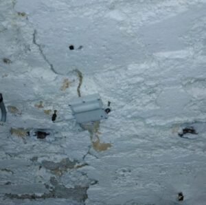 R1 wireless crackmeter installed on a concrete wall in an underground cellar